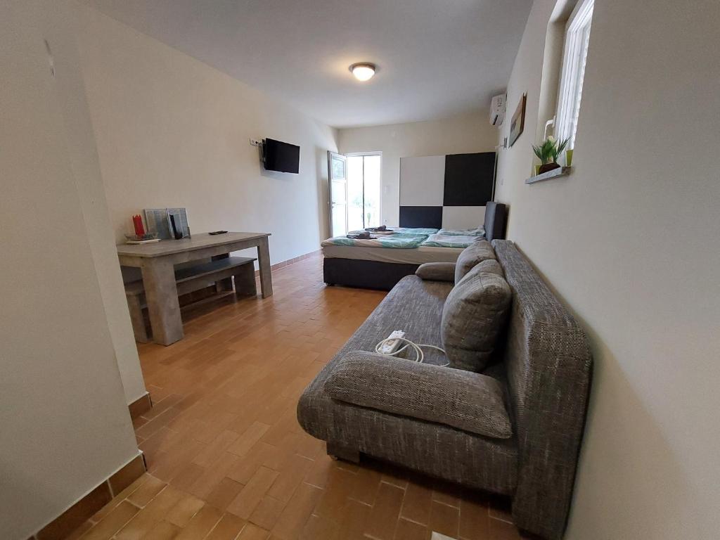 a living room with a couch and a bed at Studio apartment Aren in Porat