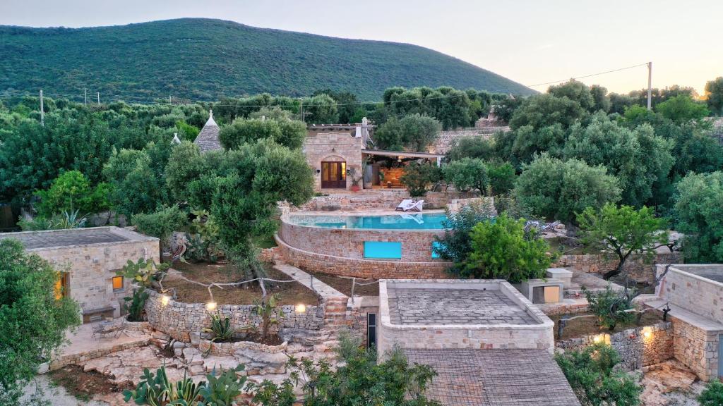 an old house with a swimming pool and a mountain at APOLLO House of Puglia in Monopoli