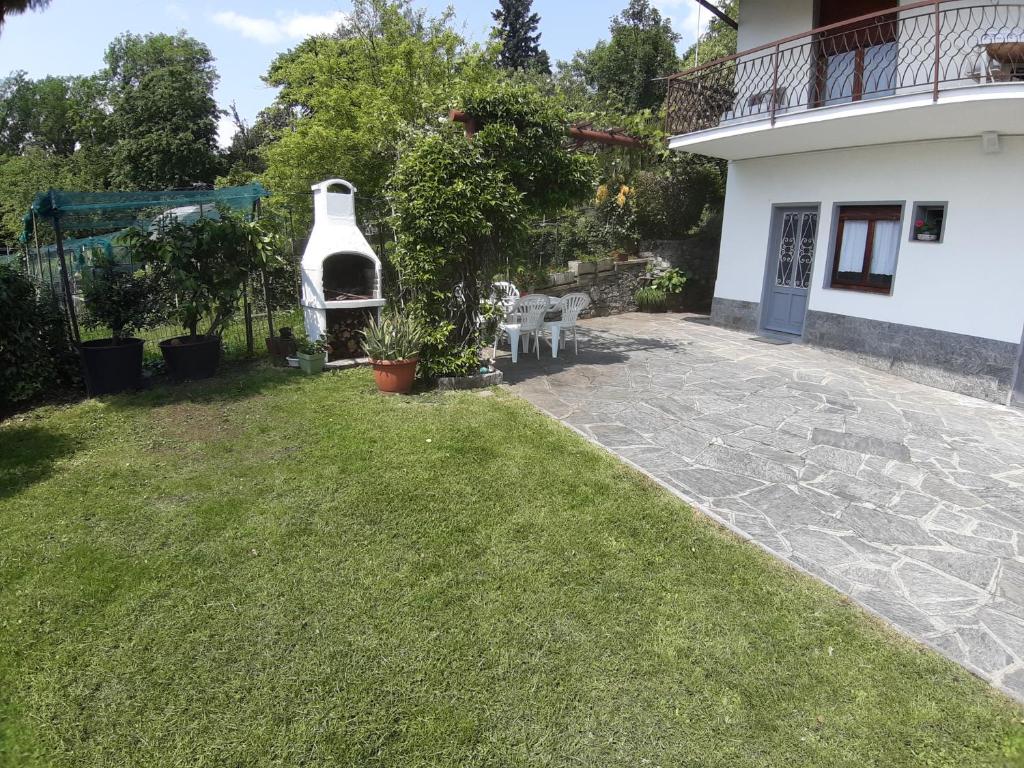 une arrière-cour avec une pelouse et une maison dans l'établissement Casa fontana rossa, à Arizzano