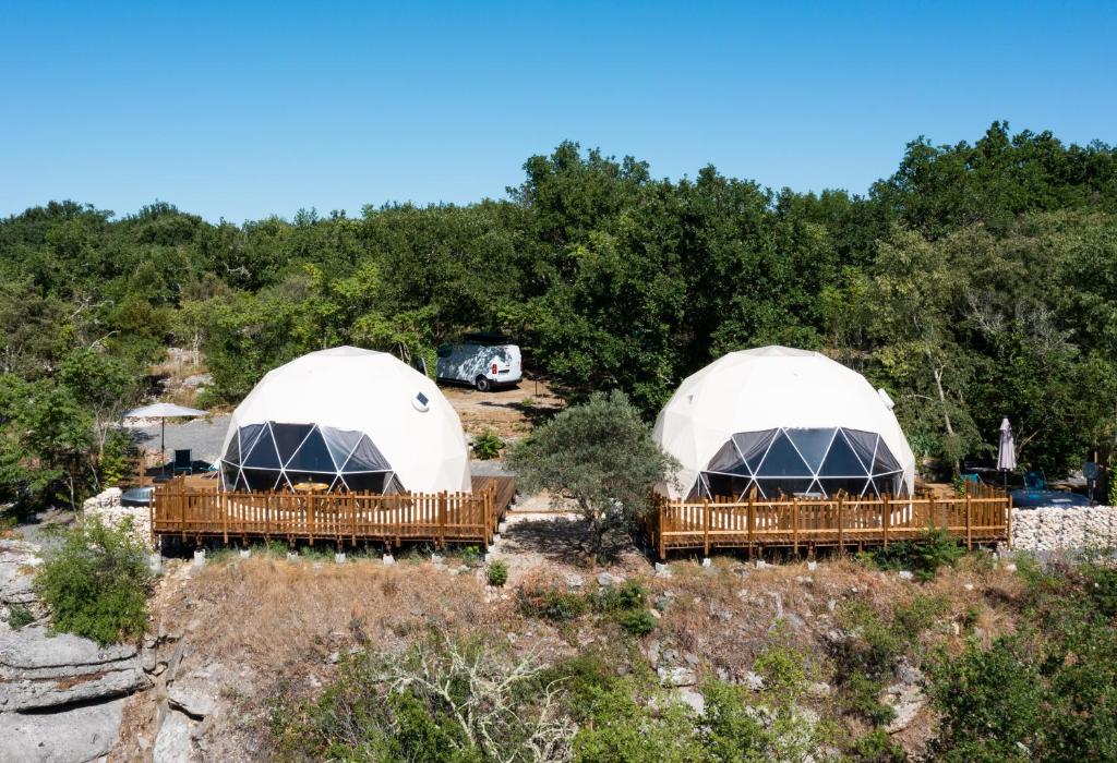 dos cúpulas en un campo con árboles en el fondo en Les Dômes des Gorges en Ruoms