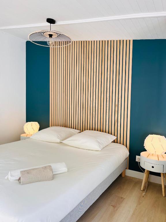 - une chambre avec un lit blanc et un mur rayé dans l'établissement Chez So and Lo, à Garéoult