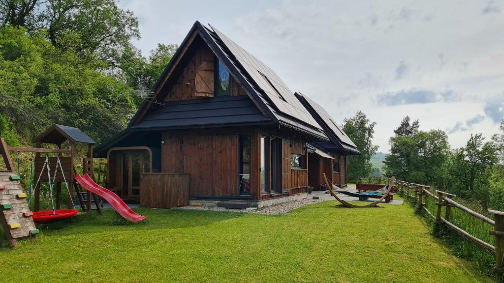 a small cabin with a red slide in a yard at Osada Knurów in Knurów