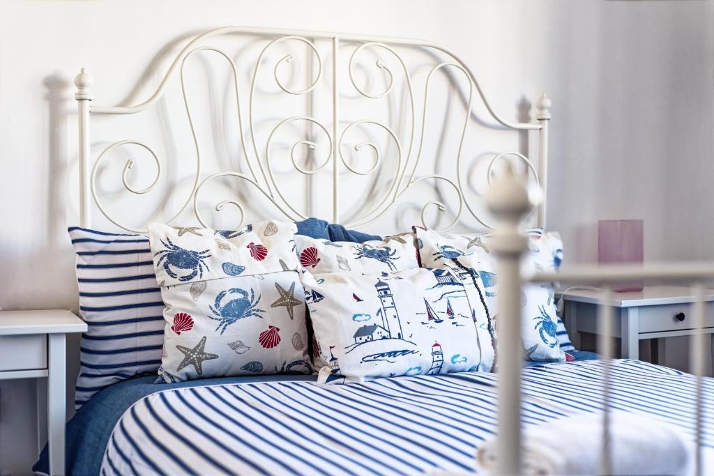 a white bed with blue and white sheets and pillows at The Shoreline Retreat in Lytham St Annes
