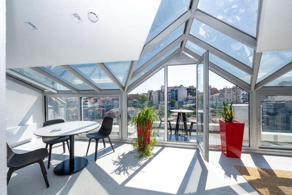 a room with a table and chairs and windows at Juno Hotel Taksim in Istanbul