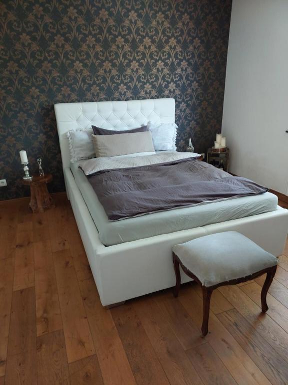 a bedroom with a white bed and a chair at private apartment in Kürten