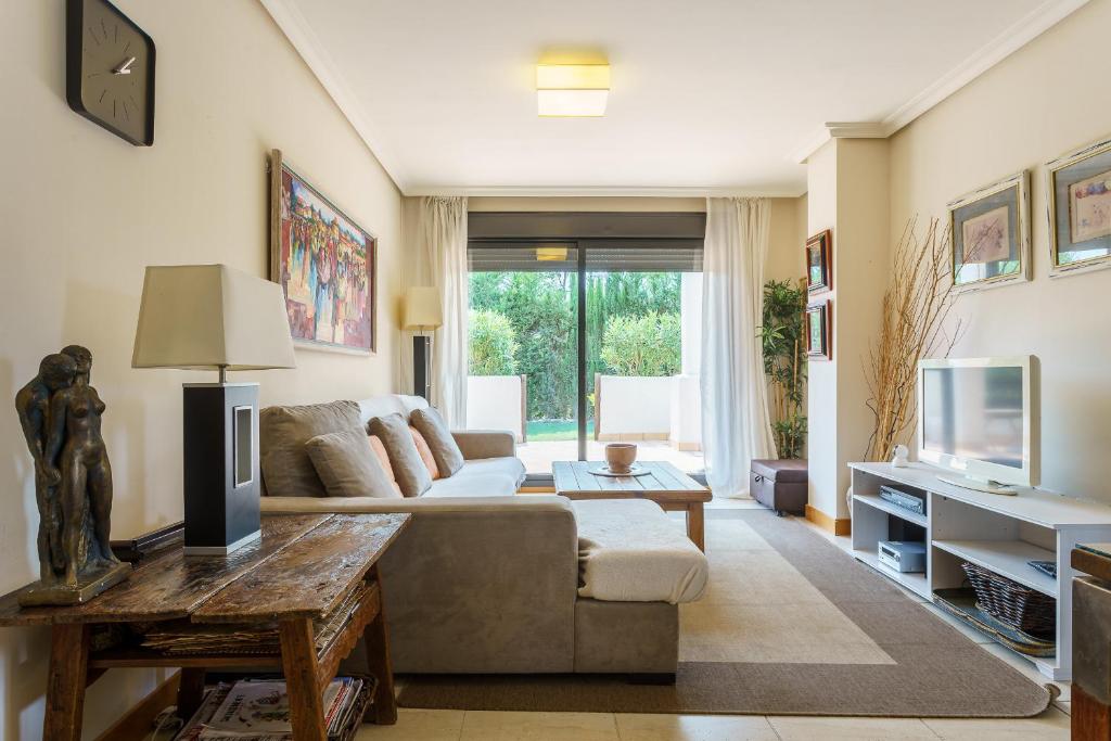 salon z kanapą i telewizorem w obiekcie Luxurious and spacious apartment with a private garden and solarium with great views in Estepona área Marbella La Resina Country Golf w mieście Estepona