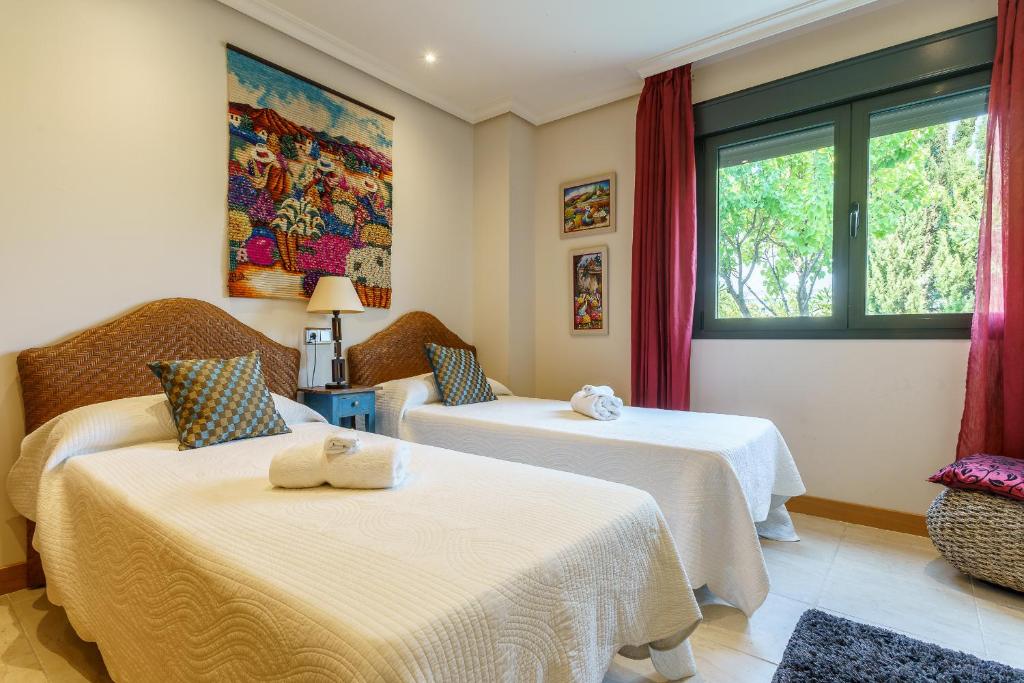 Pokój z 2 łóżkami i oknem w obiekcie Luxurious and spacious apartment with a private garden and solarium with great views in Estepona área Marbella La Resina Country Golf w mieście Estepona