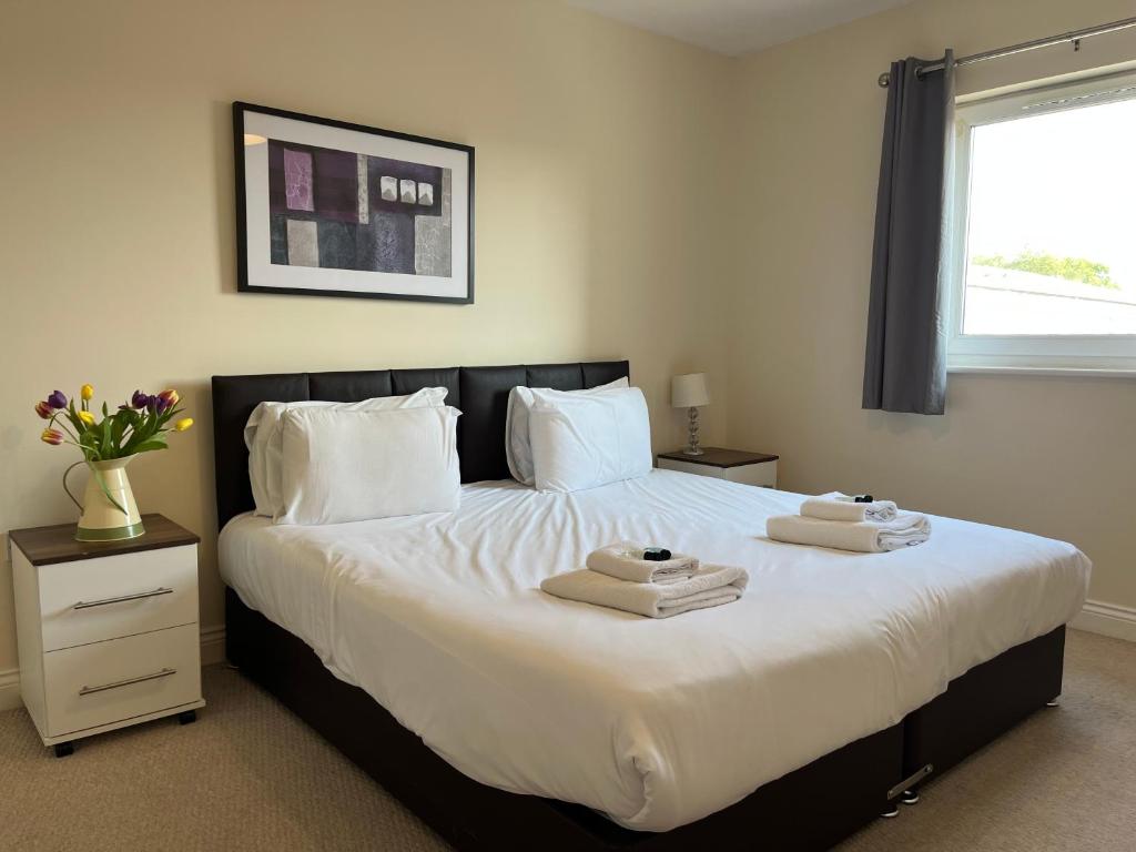 a bedroom with a large white bed with towels on it at Two Bed Flat White Star Place in Southampton