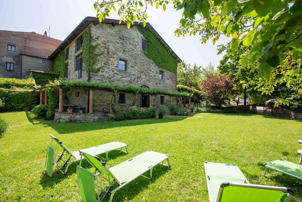 an old stone building with chairs in the yard at Casa Palmira - La Casina in Polcanto