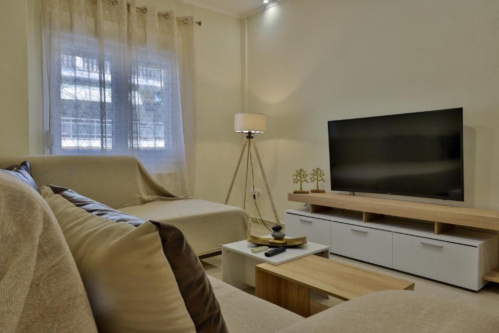 a living room with a television and a couch at antonis new apartment's 1 in Katerini