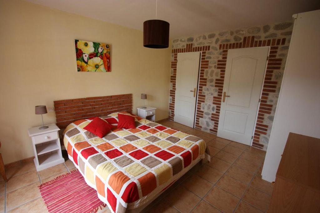 a bedroom with a bed and a brick wall at Mas Cairou in Sorède