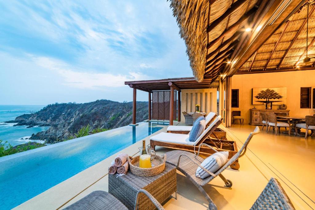 a villa with a balcony with a view of the ocean at 2012 - Villa Maroma in Santa Cruz Huatulco