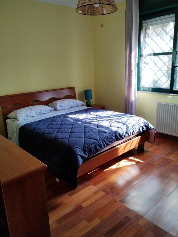 um quarto com uma cama com um edredão azul em Parco Madonnetta em Acilia
