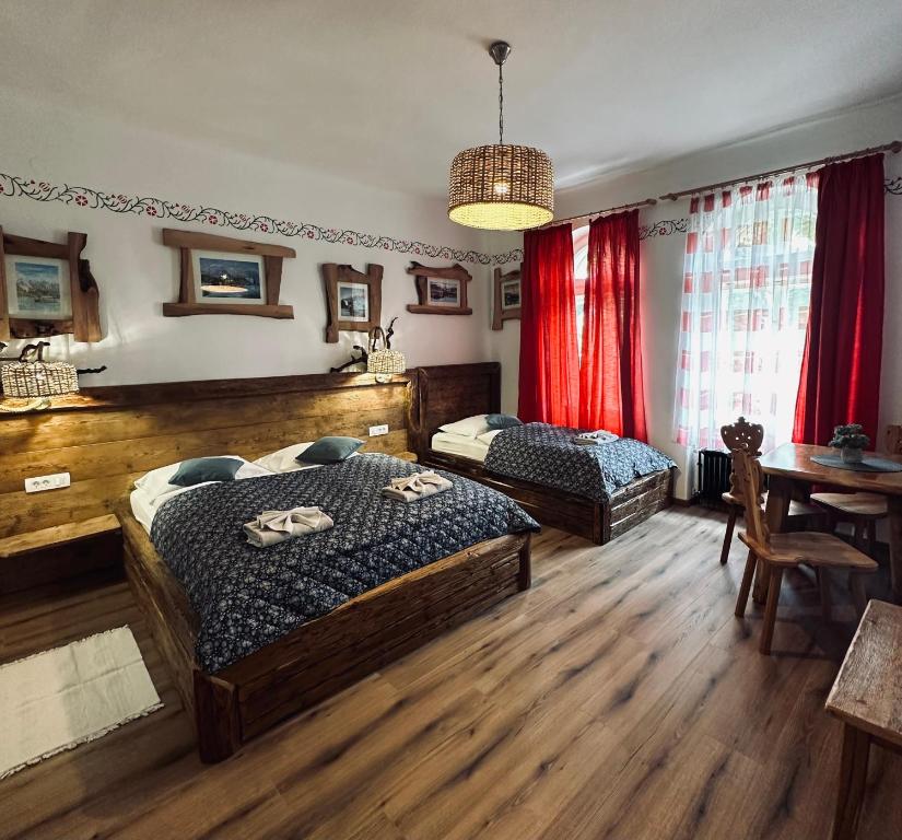 a bedroom with two beds and a table at Rooms Murka in Bled