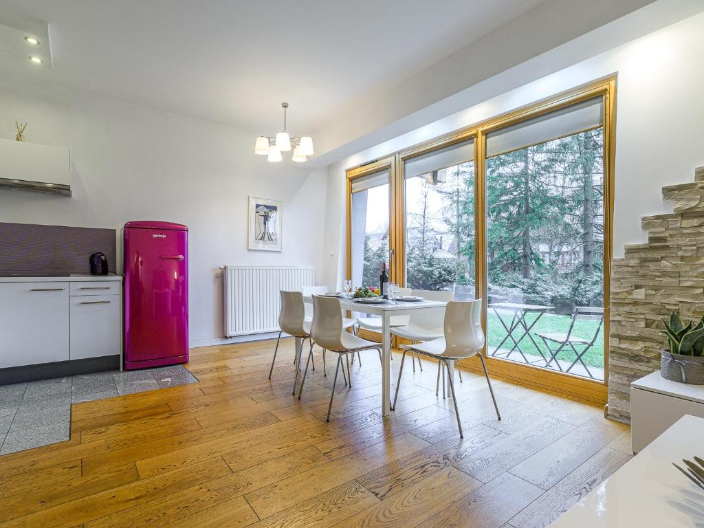 ザコパネにあるVisitZakopane - Aquapark Residence Violet Apartmentのキッチン(テーブル、椅子、赤い冷蔵庫付)