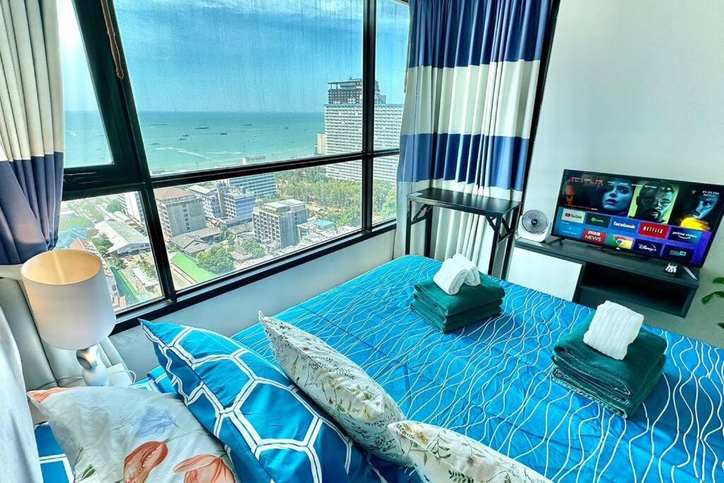 a bedroom with a blue bed with a view of the ocean at The BASE Central PATTAYA 2Bed on Sky in Pattaya Central