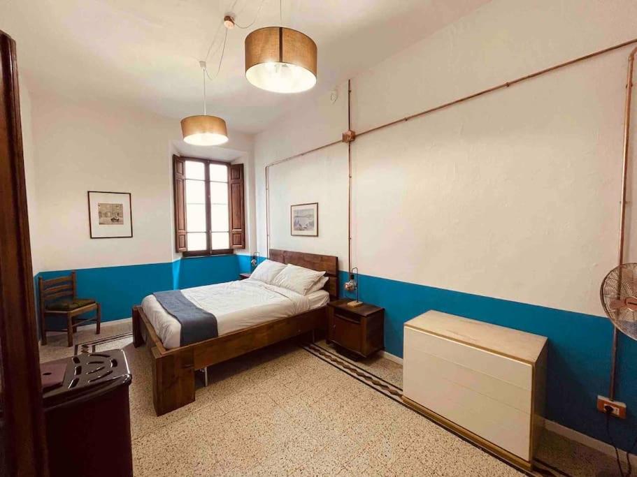 1 dormitorio con cama y pared azul en Small Town House in Tuscany, en Pontremoli