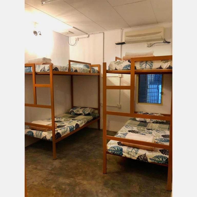 a room with three bunk beds and a window at MIMPIMOON HOSTEL Langkawi in Pantai Cenang