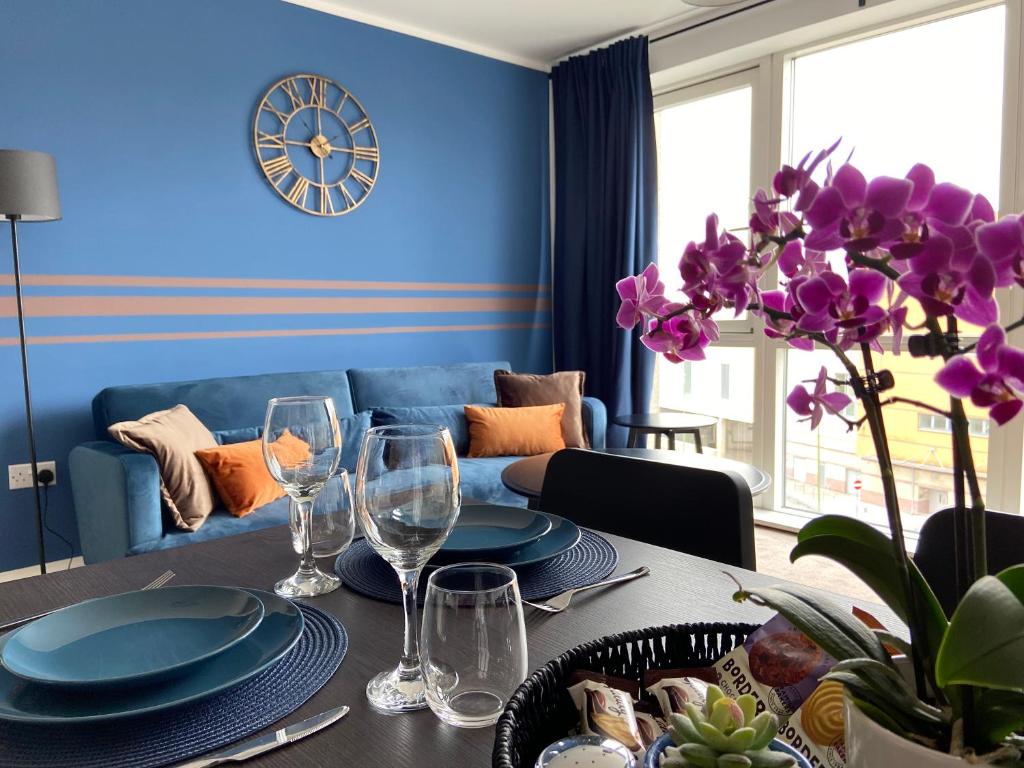 a blue living room with a table with plates and wine glasses at Your Perfect Business Suite, 2 beds 2 bathrooms Apartment, Free Parking, Monthly Stays, Business, Contractors in Hemel Hempstead