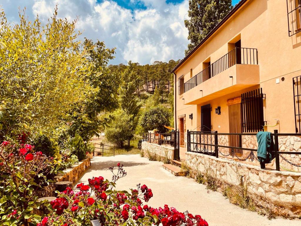 a building with red flowers in front of it at Cortijo de las cañadas in Venta de Mendoza