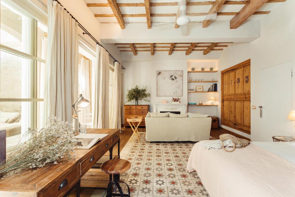 een slaapkamer met een bed, een bureau en een bank bij Jardí de Ses Bruixes Boutique Hotel in Mahón