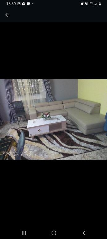 RESIDENCE LES MAGNOLIAS في دوالا: غرفة معيشة مع أريكة وطاولة قهوة