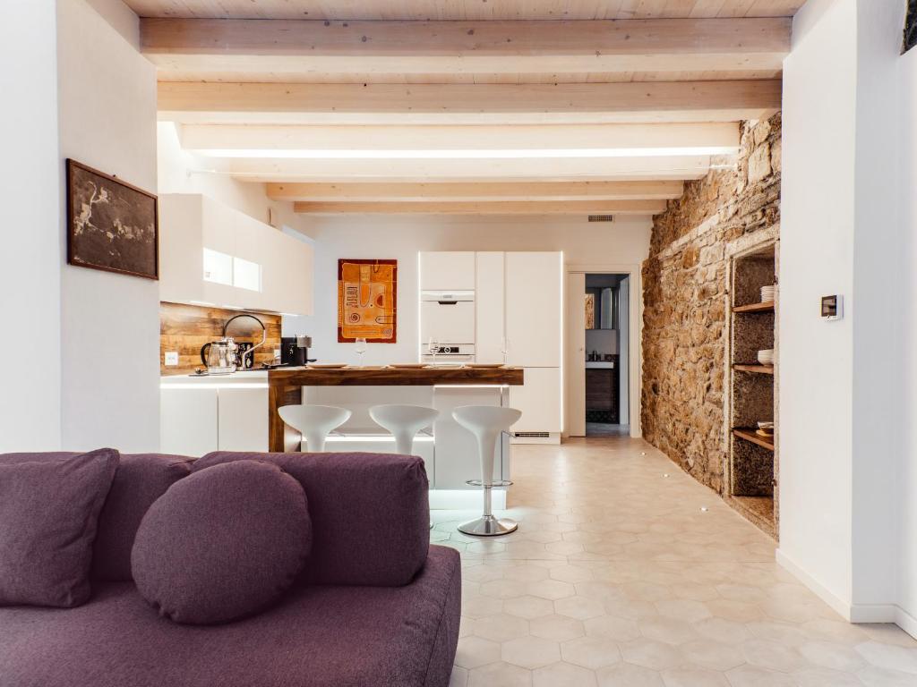 a living room with a purple couch and a kitchen at Ca Luigia in Montorfano in Mergozzo