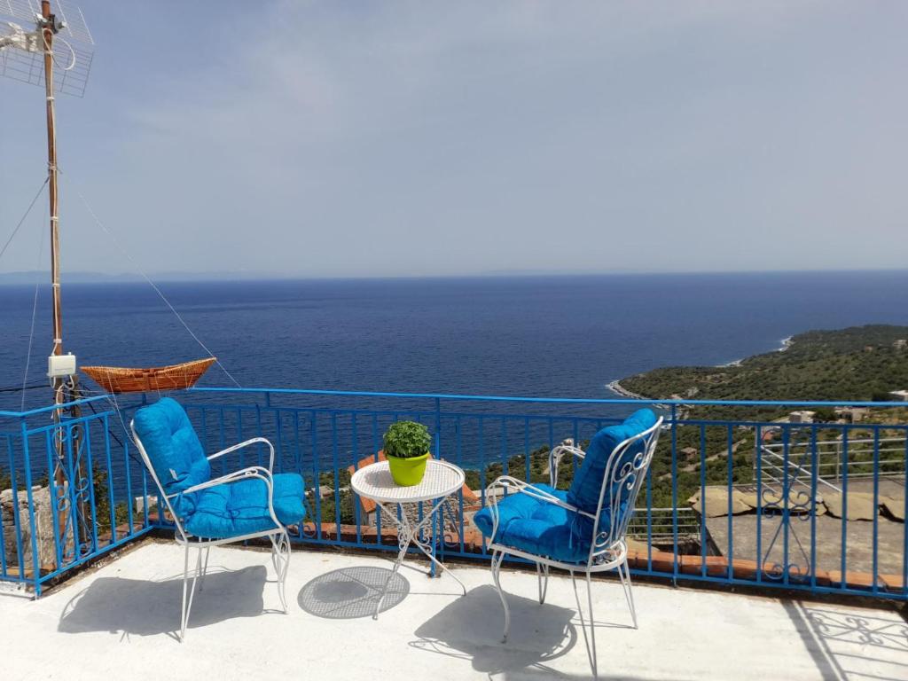 a balcony with chairs and a table and the ocean at Niki's view in Agriliá
