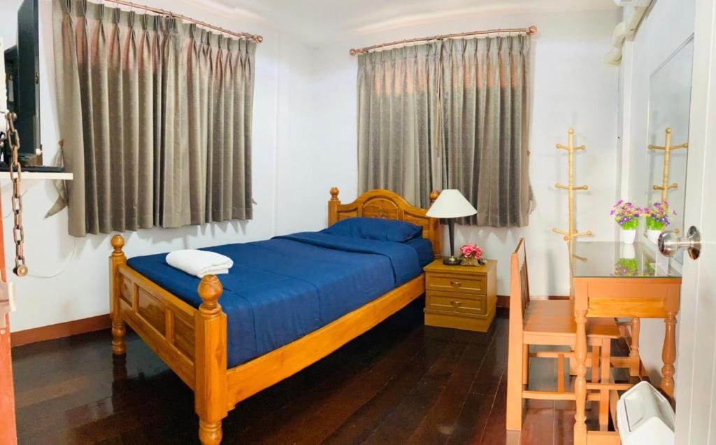a bedroom with a bed and a table and a chair at The Best House&Hostel in Ban Don Muang (1)