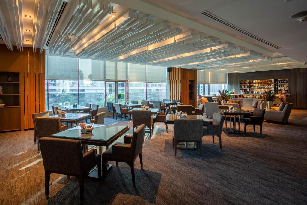 a restaurant with tables and chairs and a bar at Amari Bangkok in Bangkok