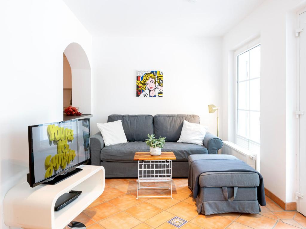 a living room with a couch and a tv at Lieblingsort Lachen in Timmendorfer Strand