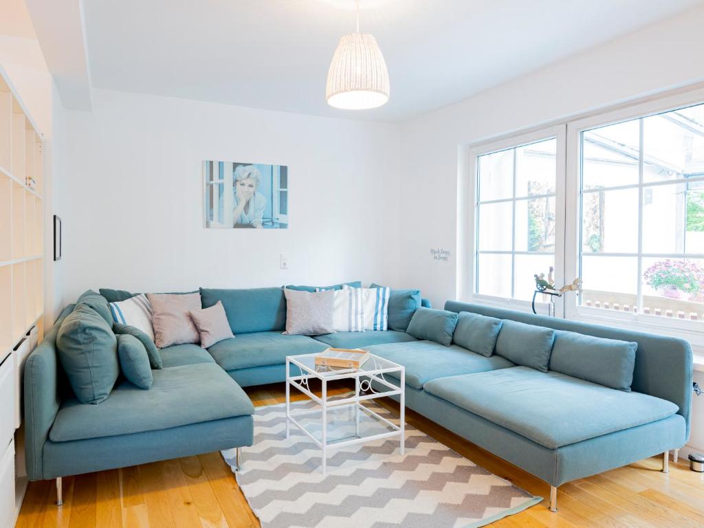 uma sala de estar com um sofá azul e uma mesa em Lieblingsort fröhlichkeit em Timmendorfer Strand