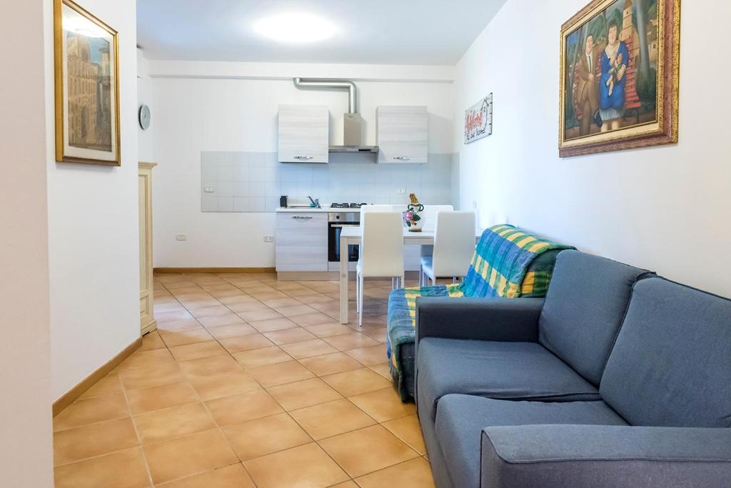 ein Wohnzimmer mit einem blauen Sofa und einer Küche in der Unterkunft SE014 - Senigallia, nuovo bilocale comodo a centro e spiaggia in Senigallia