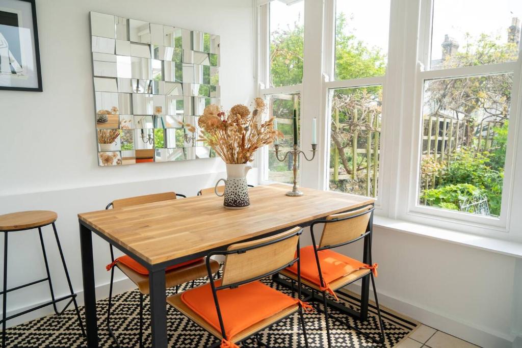a dining room with a wooden table and chairs at Stylish two bedroom terrace with garden in Ramsgate