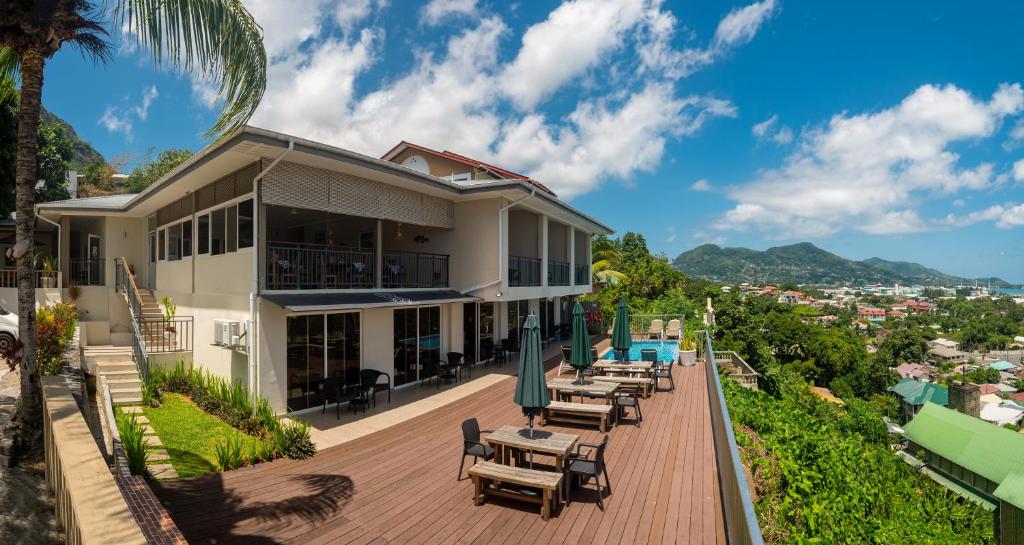 una casa con mesas y sillas en una terraza en The Ridge Residence en Victoria