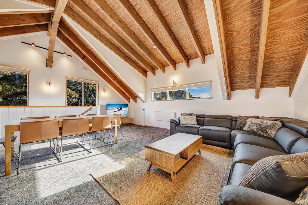 - un salon avec un canapé et une table dans l'établissement The Penthouse @ Alpine Haven, à Mount Hotham