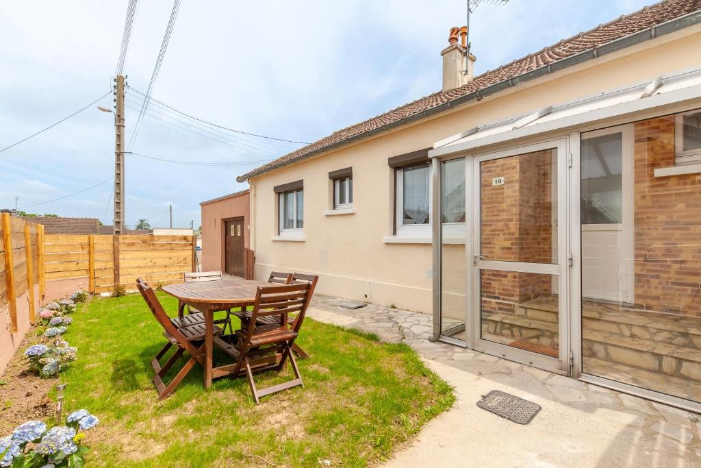 eine Terrasse mit einem Tisch und Stühlen vor einem Haus in der Unterkunft Gîte Renardeau - Maison à deux pas du centre ville in Carentan