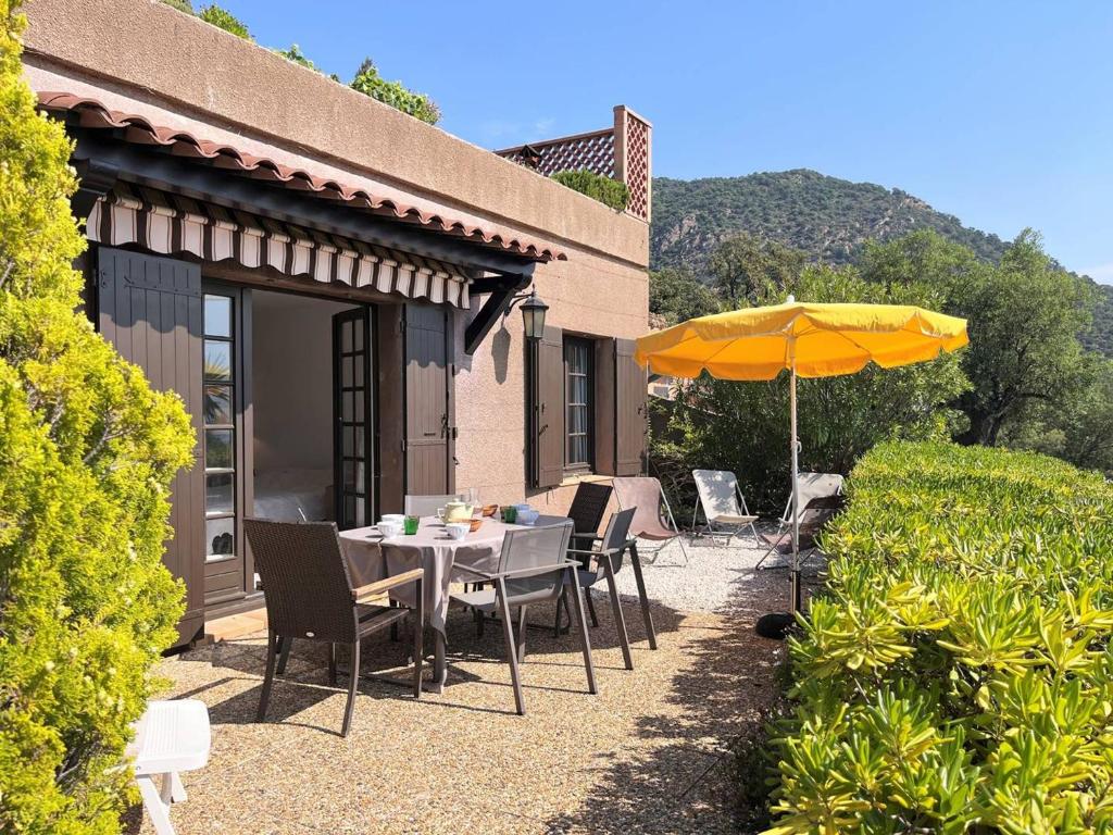 une terrasse avec une table et un parasol dans l'établissement Maison Le Lavandou, 3 pièces, 6 personnes - FR-1-251-502, au Lavandou