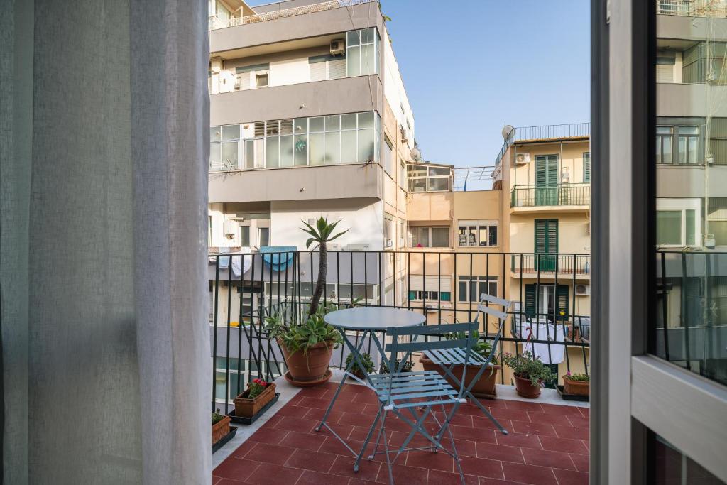 eine Terrasse mit einem Tisch und Stühlen auf dem Balkon in der Unterkunft Giusà by DomuSicily in Palermo
