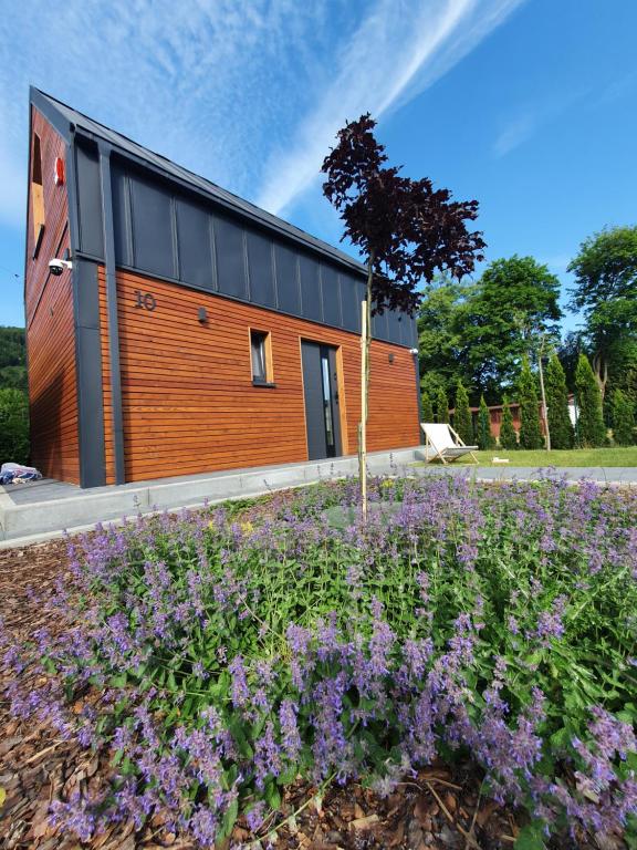 a house with a garden with purple flowers at Domek na Polanie in Ustroń