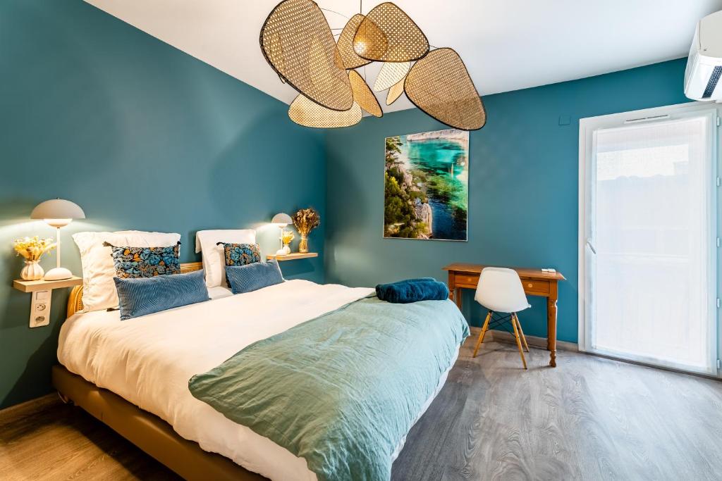 a bedroom with a large bed and a blue wall at Le Nani Raou par Dodo à Cassis in Cassis