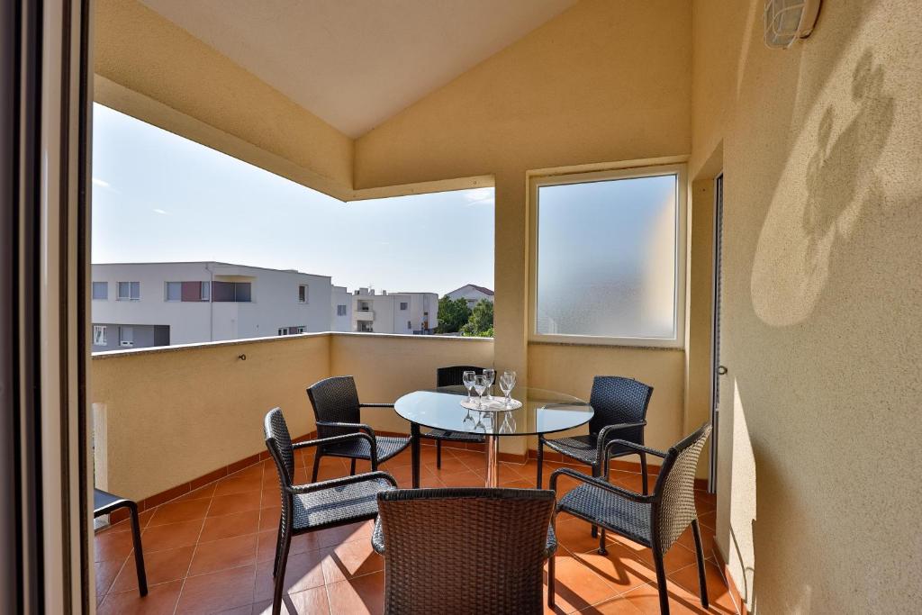 a dining room with a table and chairs on a balcony at Smiley 2 in Novalja