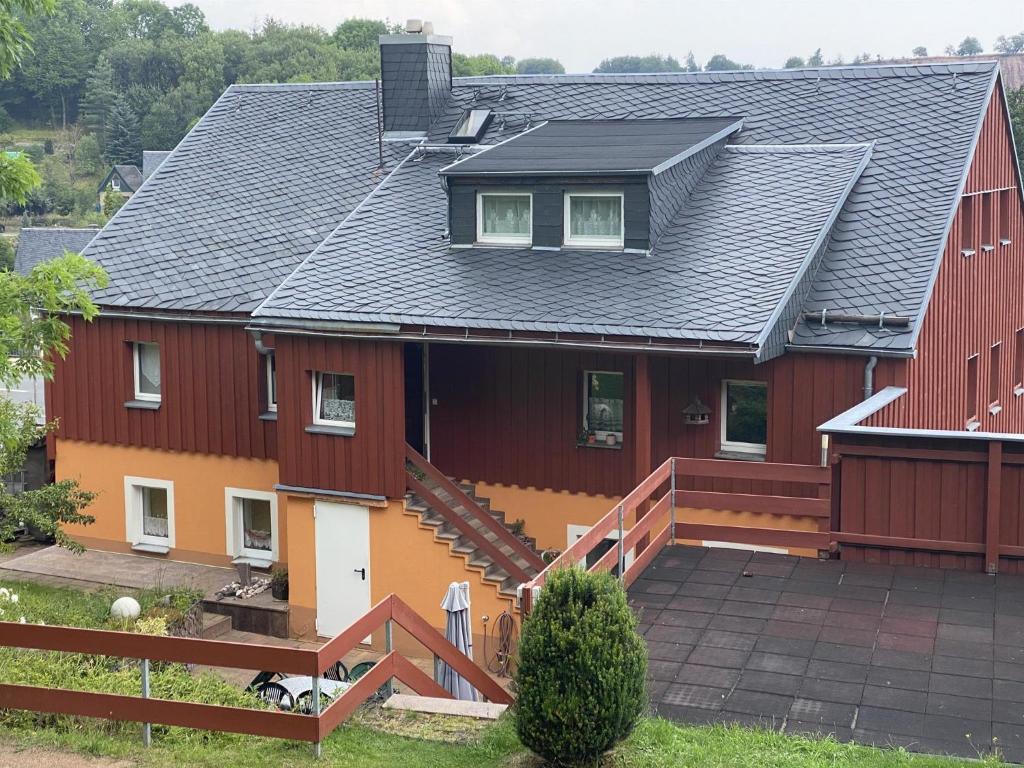 ein großes rotes Haus mit schwarzem Dach in der Unterkunft Ferienwohnung Mäschker in Kurort Altenberg