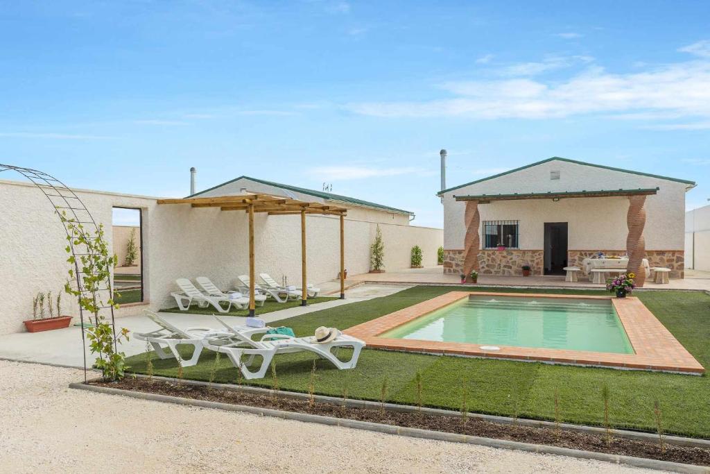 a backyard with a swimming pool and a house at Casa Rural María Lantejuela in La Lantejuela
