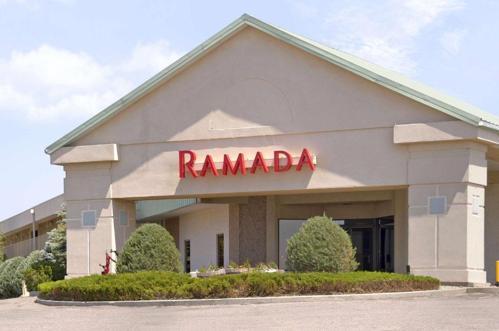 a ramada building with a red sign on it at Ramada by Wyndham Sterling in Sterling
