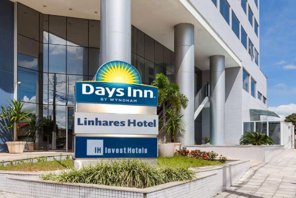 a sign in front of a building at Days Inn by Wyndham Linhares in Linhares