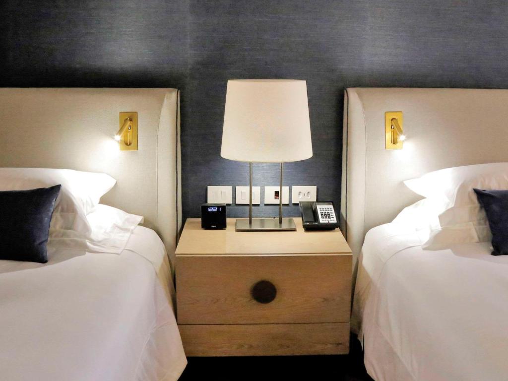 sypialnia z 2 łóżkami i lampką na stoliku nocnym w obiekcie Fairmont Rio de Janeiro Copacabana w mieście Rio de Janeiro