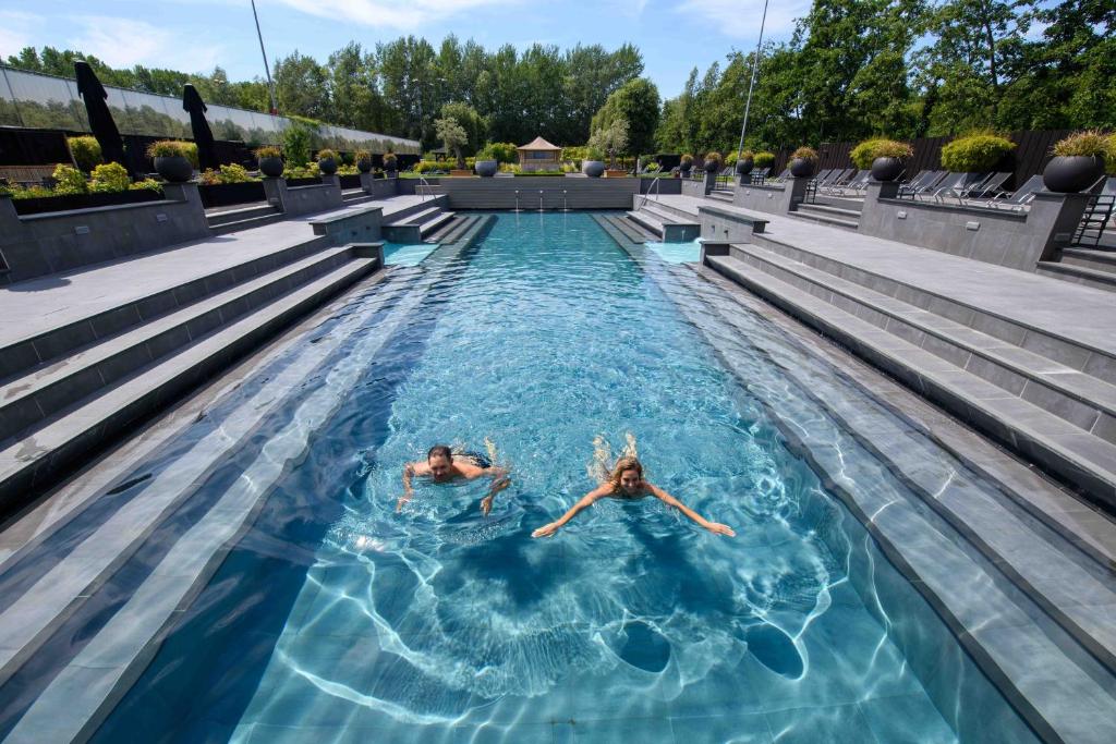 twee personen zwemmen in een zwembad bij Hotel & Wellness Zuiver in Amsterdam