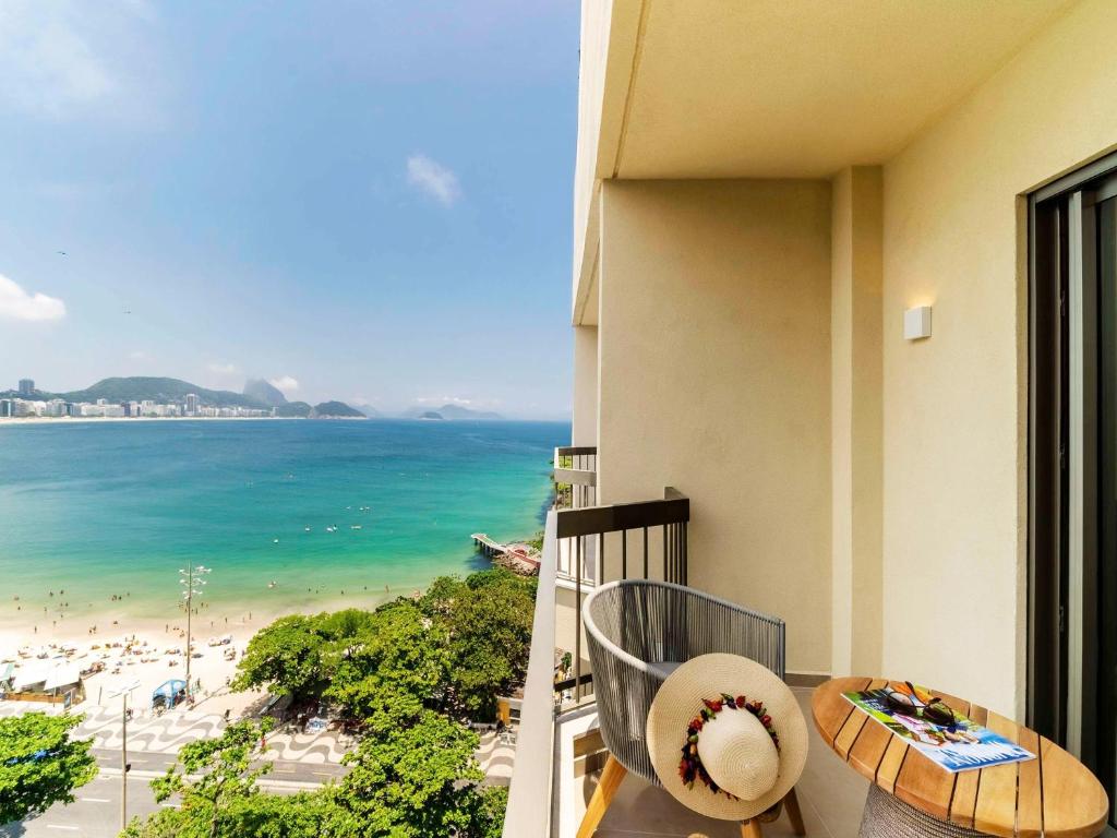 a balcony with a table and a view of the beach at Fairmont Rio de Janeiro Copacabana in Rio de Janeiro