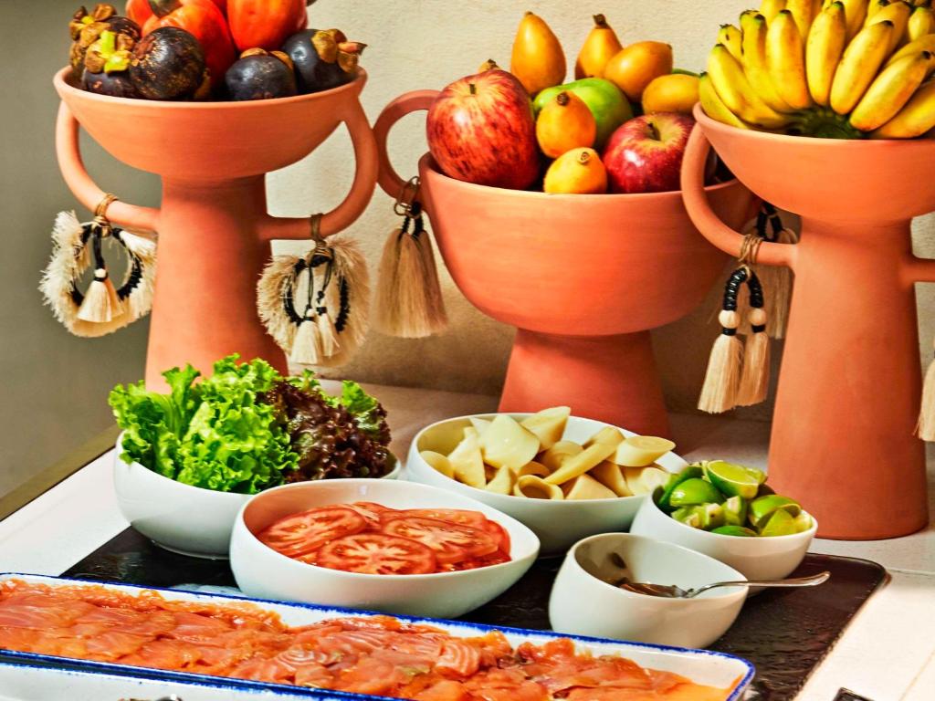 a table with bowls of different types of fruits and vegetables at Fairmont Rio de Janeiro Copacabana in Rio de Janeiro